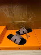 Black slide sandals with light gray strap and cutout center detail