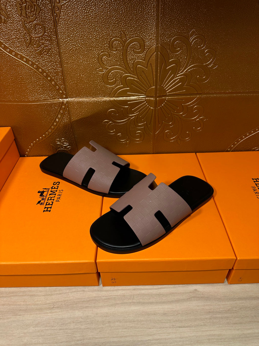 Pair of black slide sandals with light gray strap and open-toe design