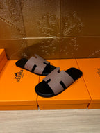 Pair of black slide sandals with light gray strap and open-toe design