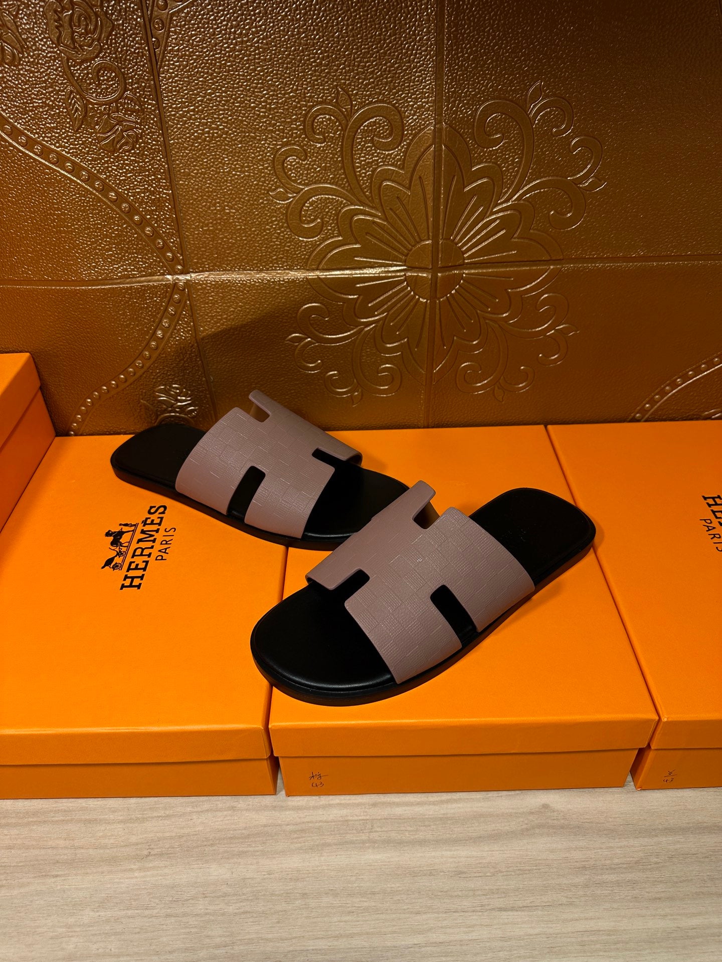 Pair of black slide sandals with light gray strap and open-toe design