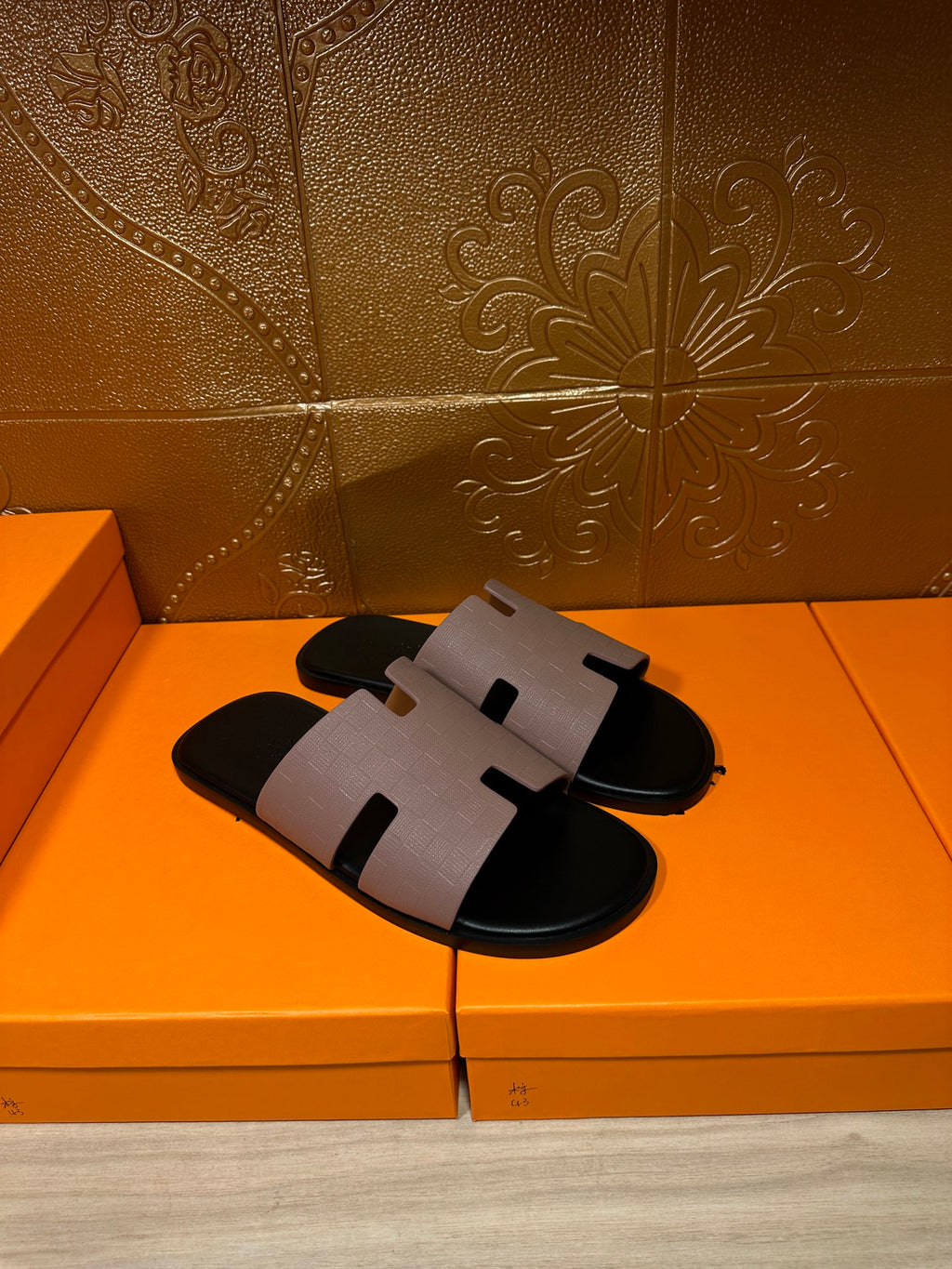 Light gray and black slide sandals with wide strap and squared open-toe top