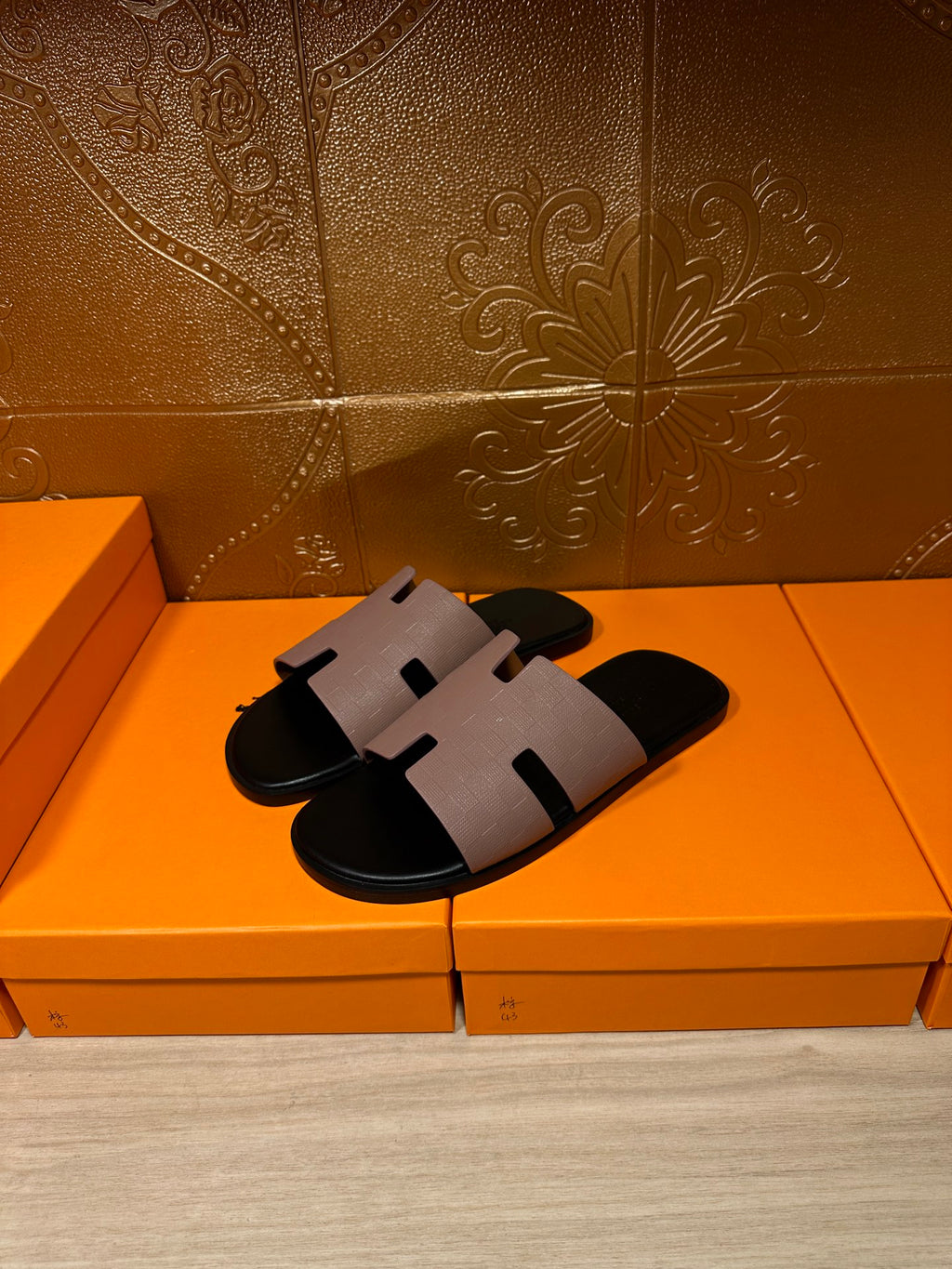 Black slide sandals with light gray wide strap across the foot and open-toe silhouette