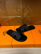 Black slide sandals with padded footbed and wide textured straps