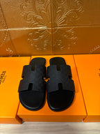 Black slide sandals with textured strap and squared toe opening