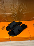 Black slide sandals with wide crossover textured straps