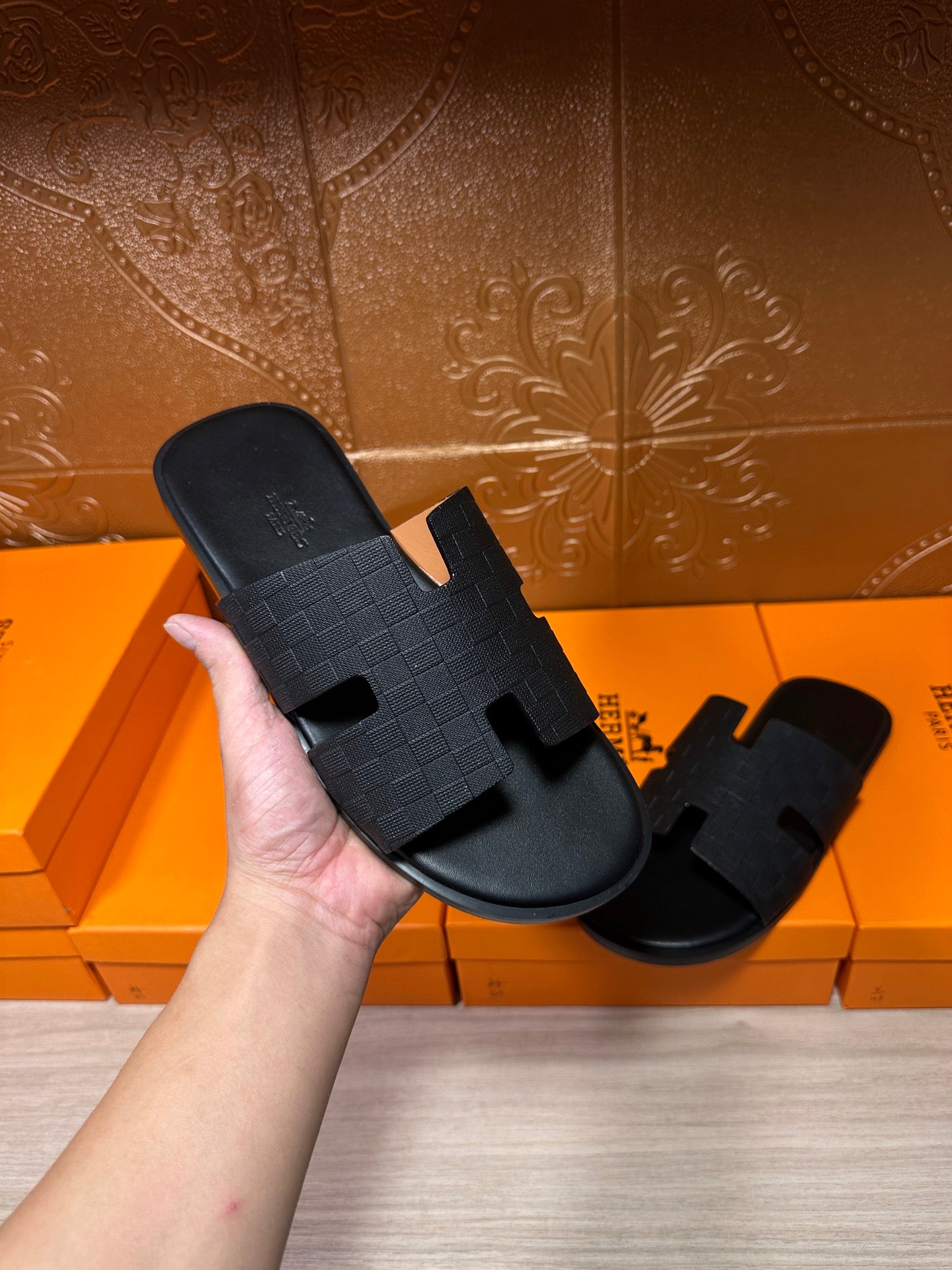 Black slide sandal in hand with textured strap and open toe