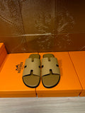 Beige slide sandals with embossed cross straps and open toe