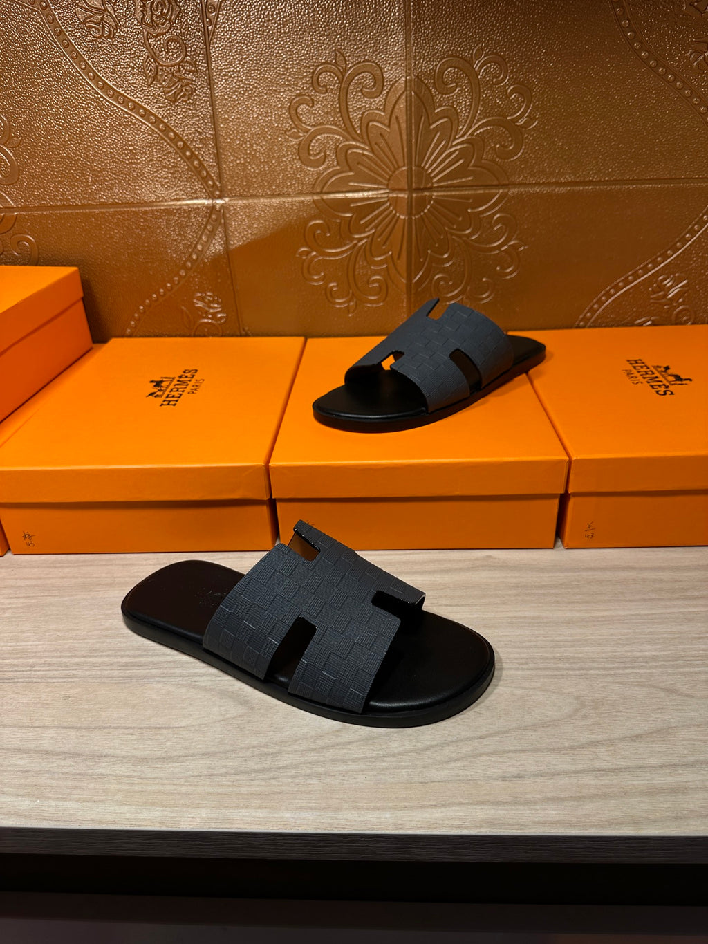 Hermes slide sandals with dark blue textured H strap, front and side view