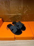Hermes dark blue slide sandals with wide molded H band and black footbed