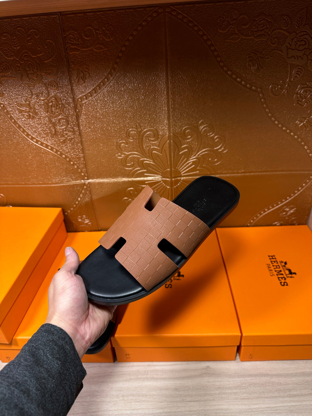 Tan leather slide sandal with black footbed and H-style strap, close view