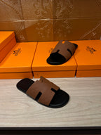 Tan leather slide sandal and matching pair, black sole with H-style strap