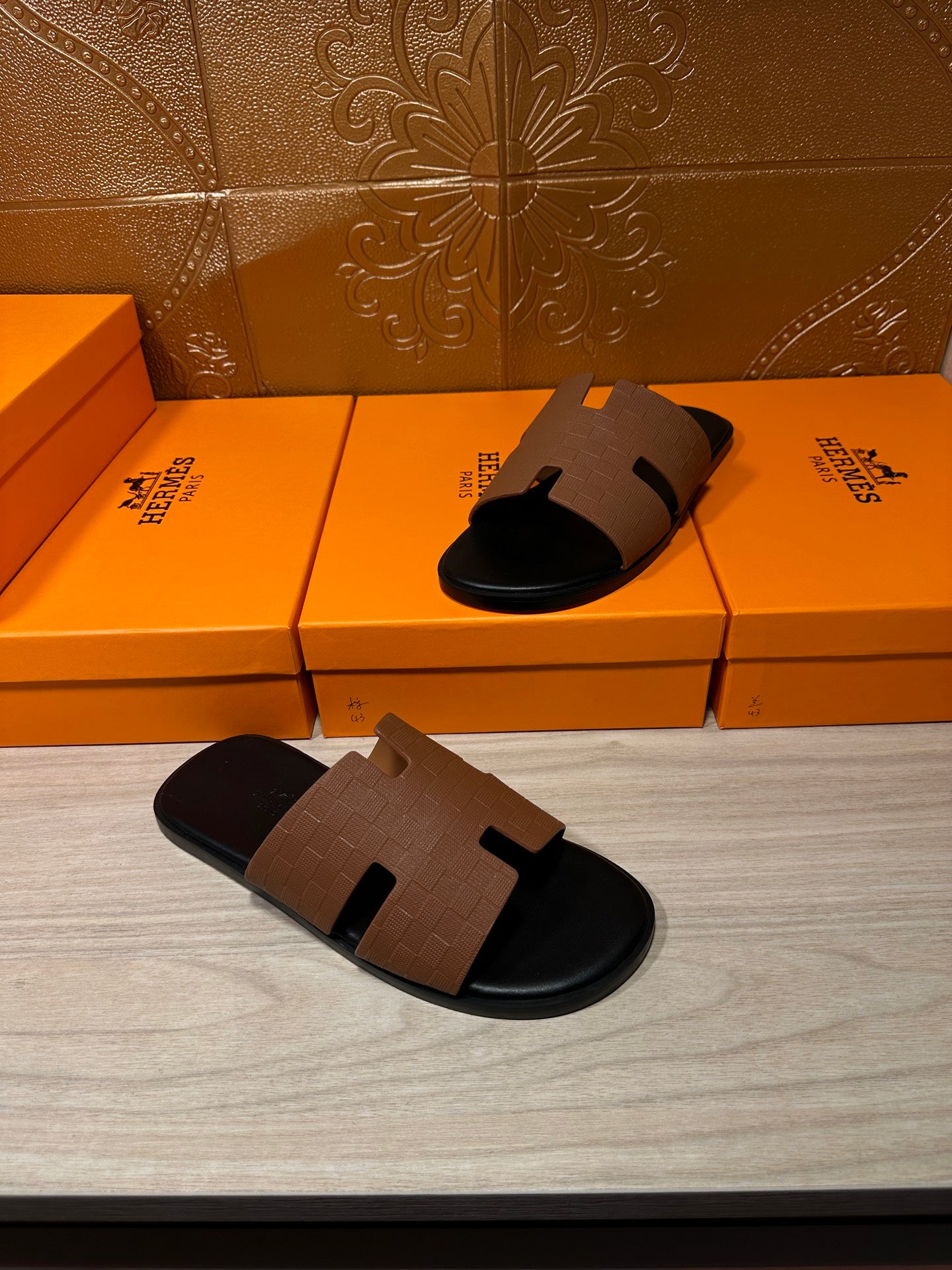 Tan leather slide sandal and matching pair, black sole with H-style strap