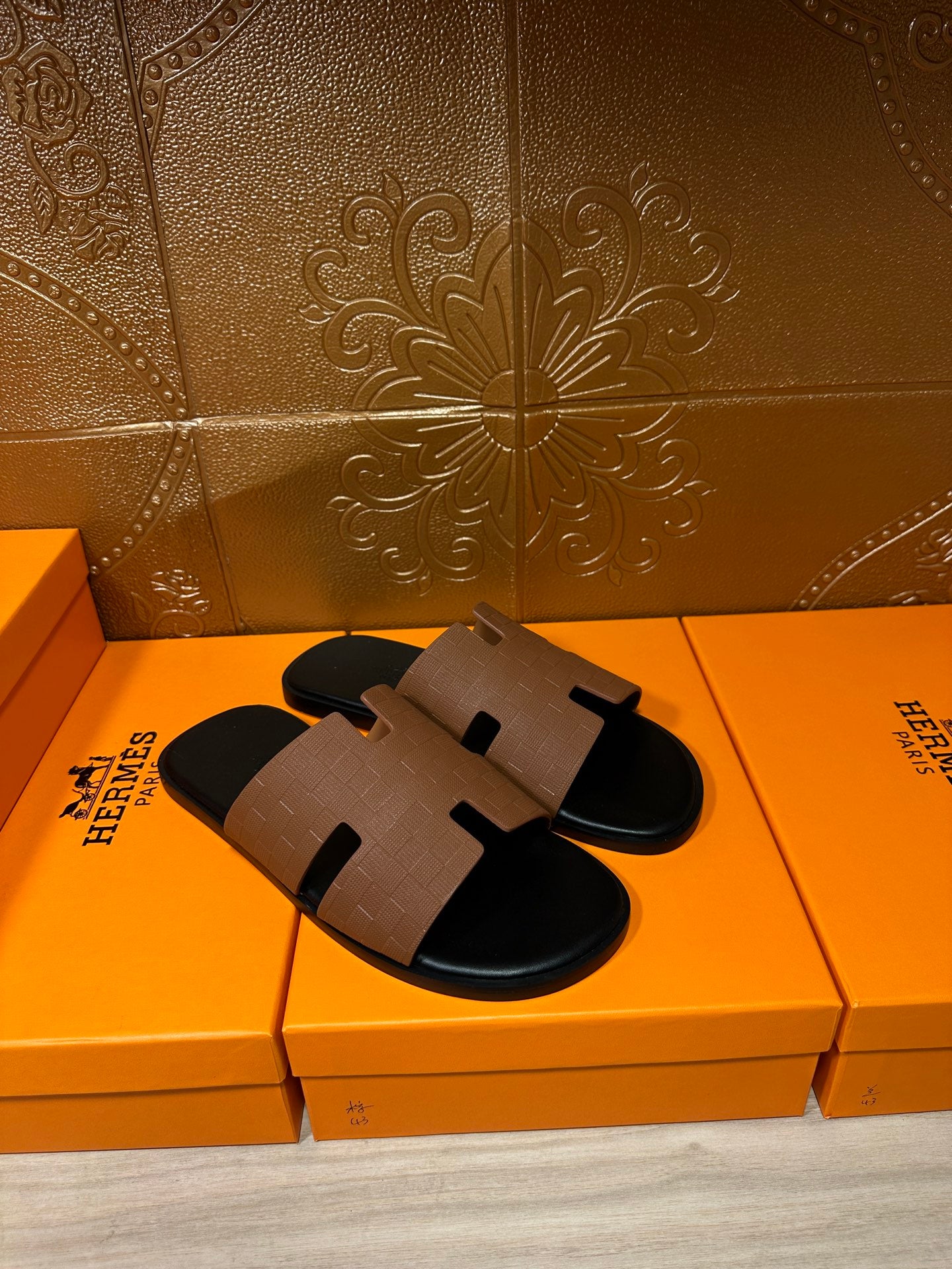 Tan leather slide sandal with black rubber sole and H-style strap, side view