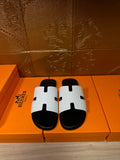 Hermes slide sandals with white strap and black footbed, front H-cutout detail