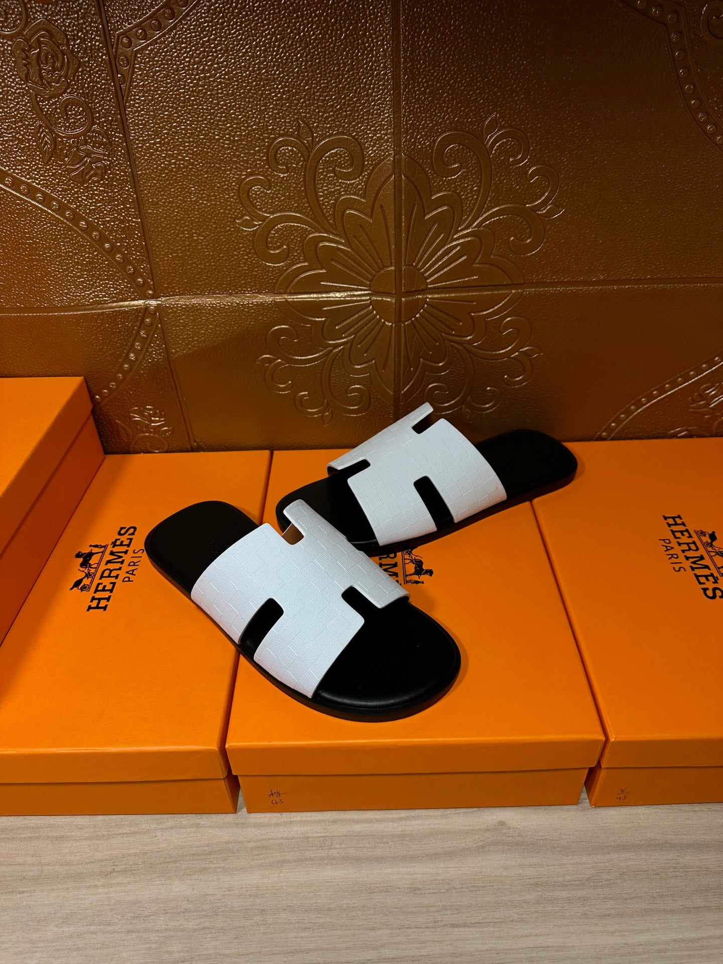 Hermes slide sandals, white and black with H-cutout straps, angled side view