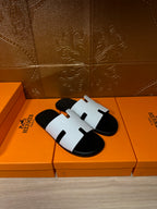 Hermes slide sandals pair with white straps on black footbeds, H-cutout detail