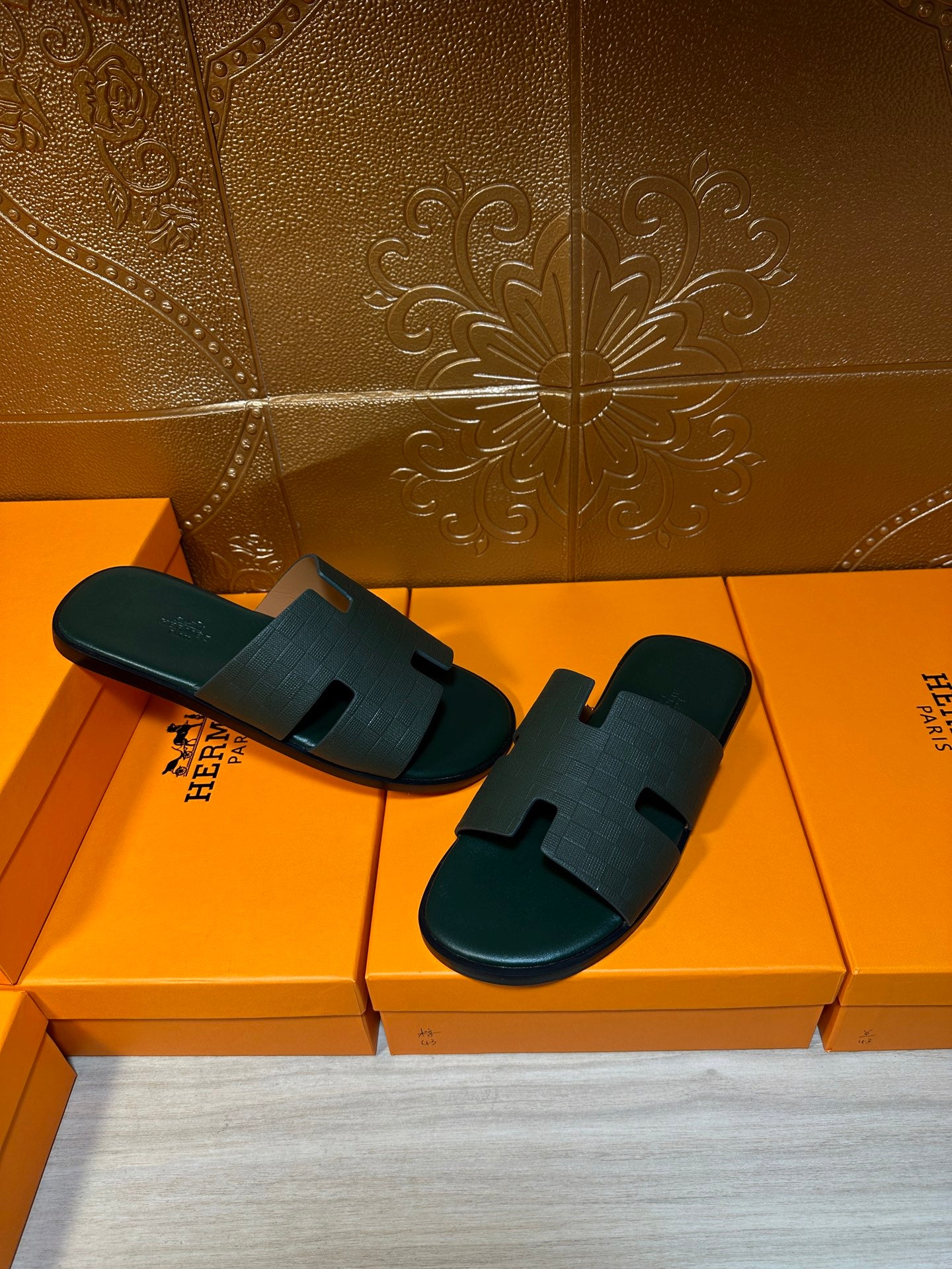 Hermes slide sandals on box, dark green open-toe with wide strap and H cutout motif