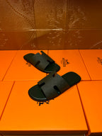 Hermes slide sandals, dark green open-toe slides with wide H-style strap