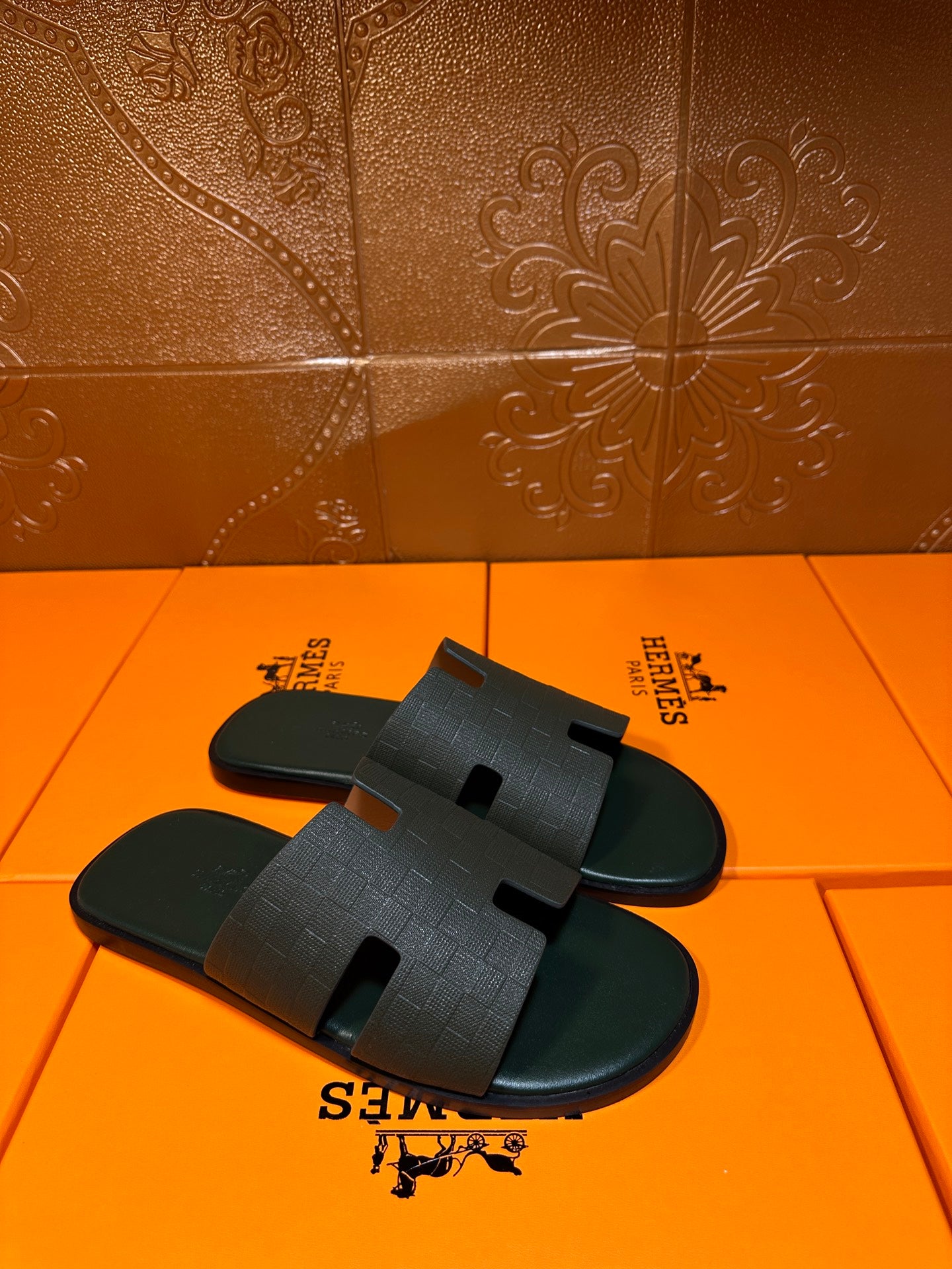 Hermes slide sandals, dark green pair with wide H-style strap over the foot