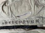Olive green jacket inner waistband with decorative symbols and two zippers
