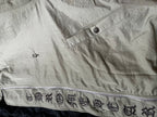 Light gray long jacket with button placket and patterned emblem graphic trim