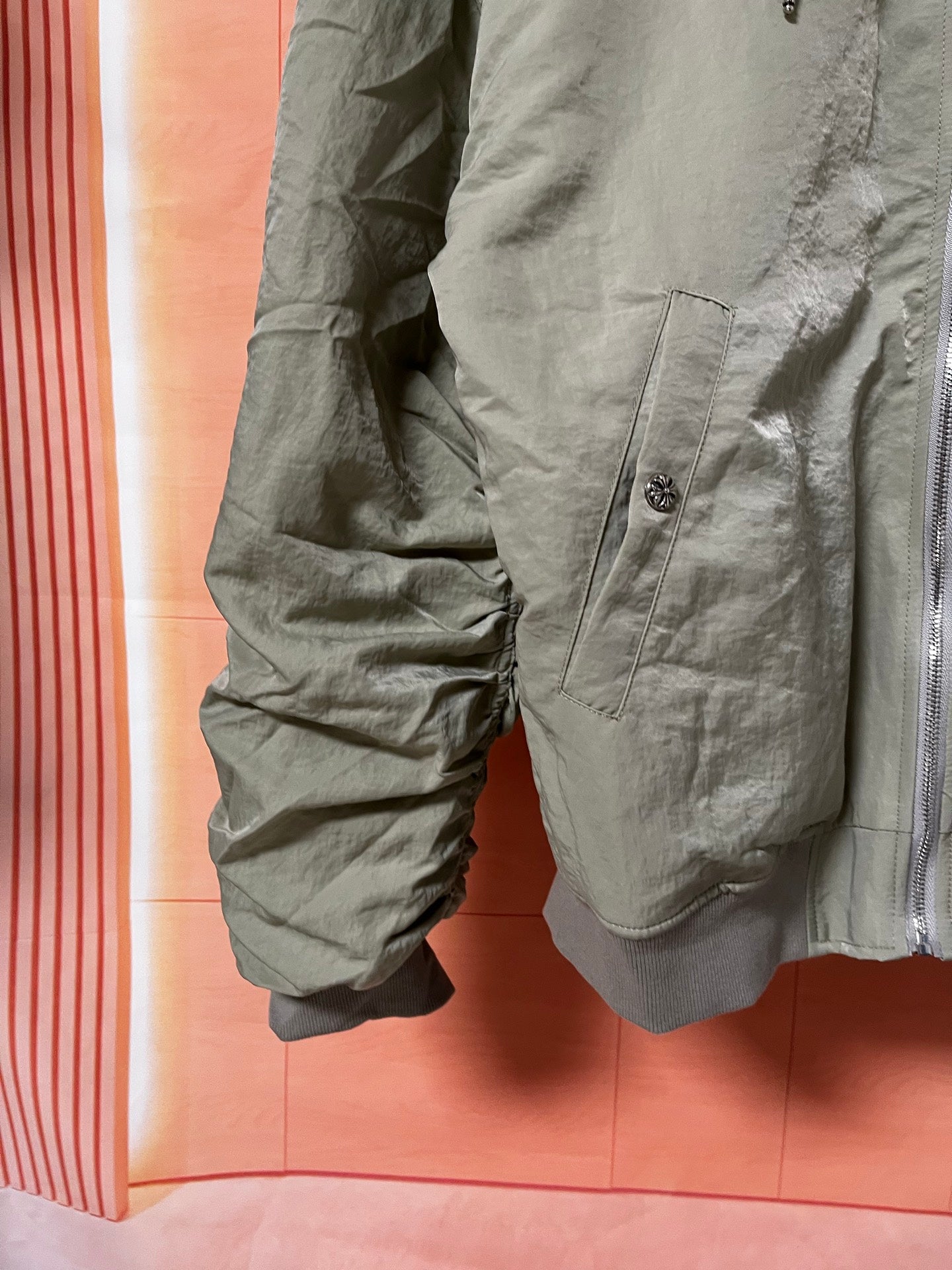 Olive green jacket with angled pocket and elastic cuff detail