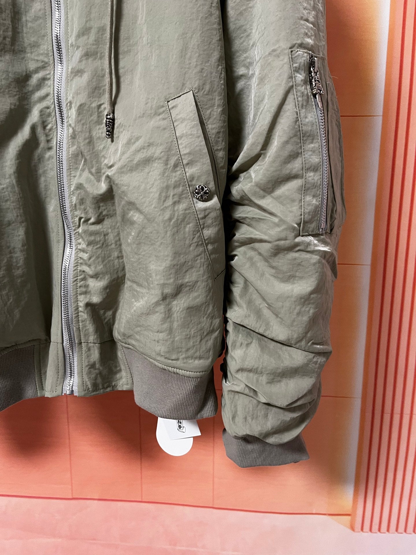 Olive green jacket sleeve pocket and side pocket with zip accents