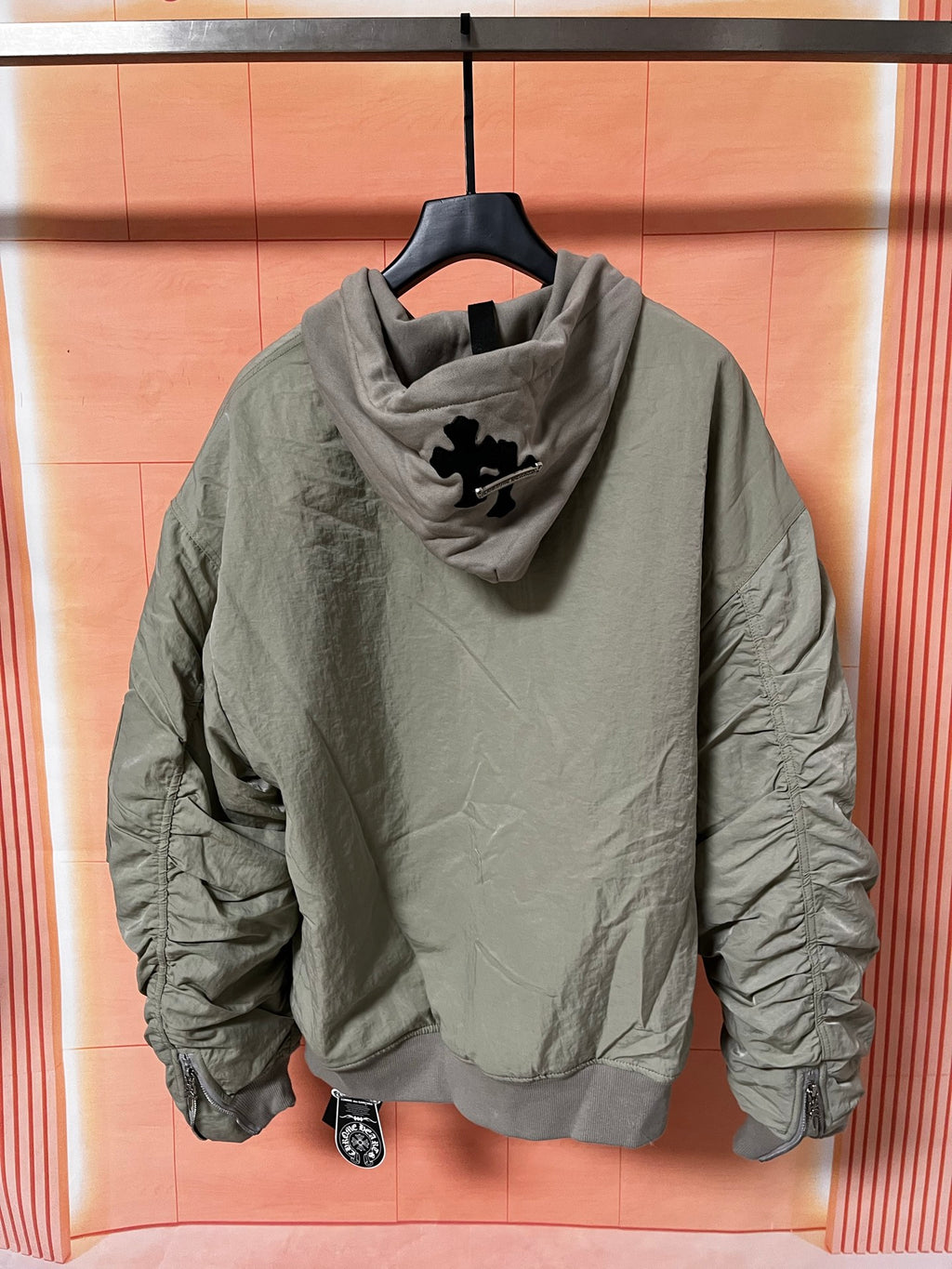 Olive green zip-up hoodie jacket with hood and logo graphic on back