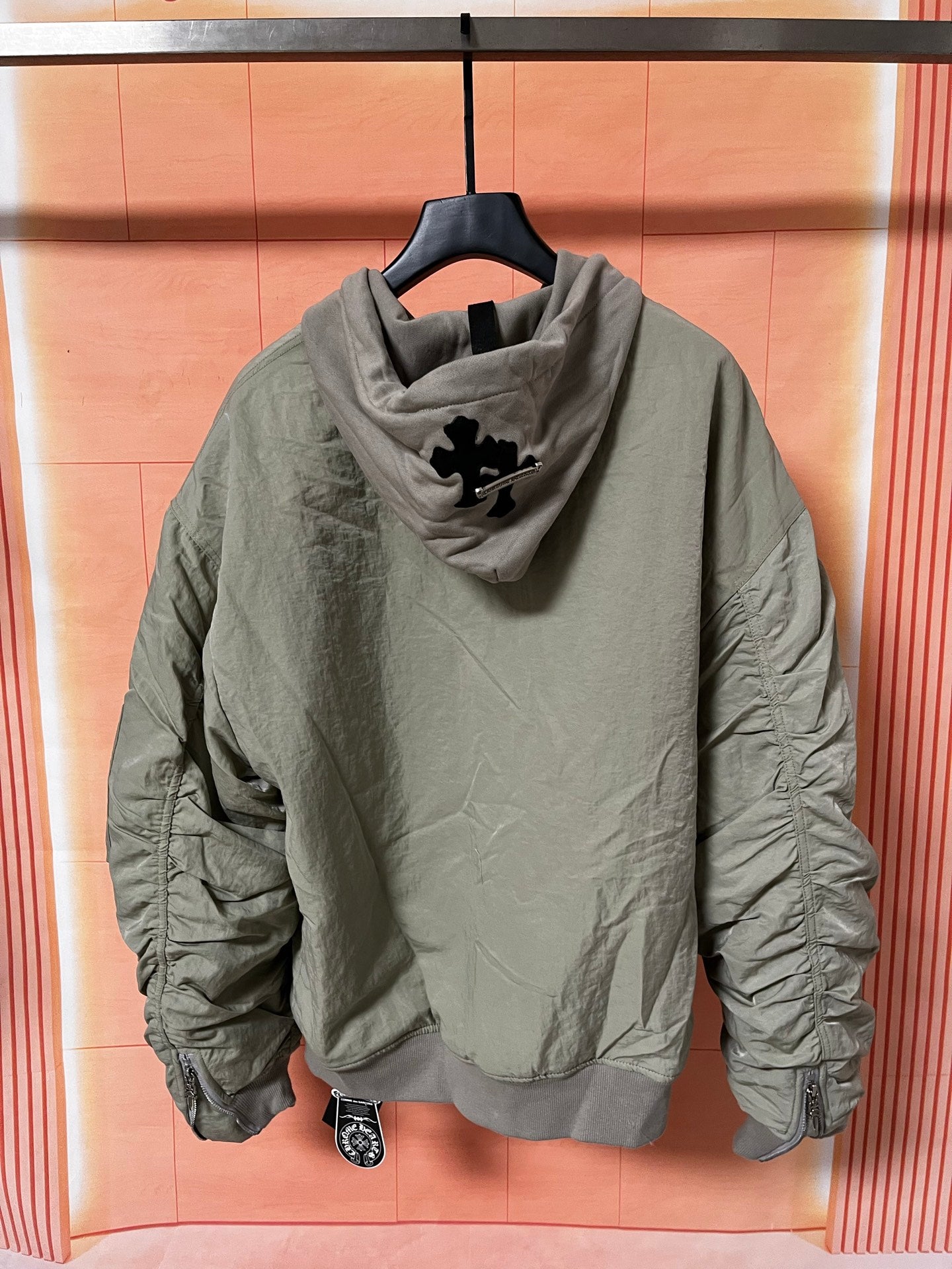 Olive green zip-up hoodie jacket with hood and logo graphic on back