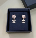 Chanel stud earrings with silver flower tops, faux pearl detail, and CC drop charms