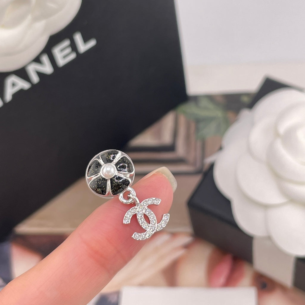 Chanel single drop earring close-up: black flower stud, faux pearl and crystal CC charm