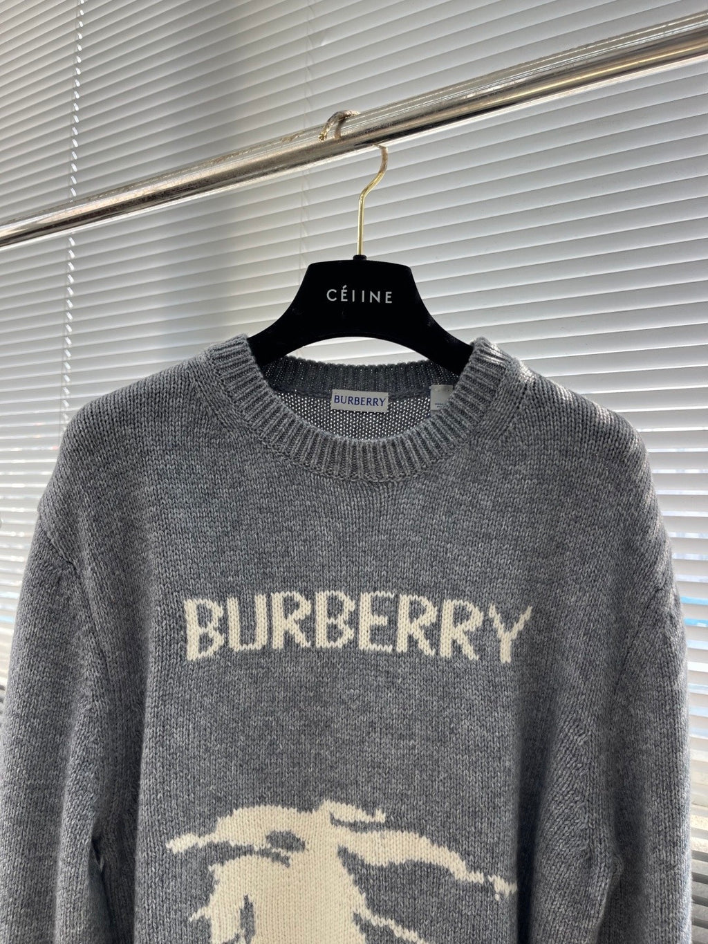 Grey knit sweater with BURBERRY text and horse graphic below, crew neck