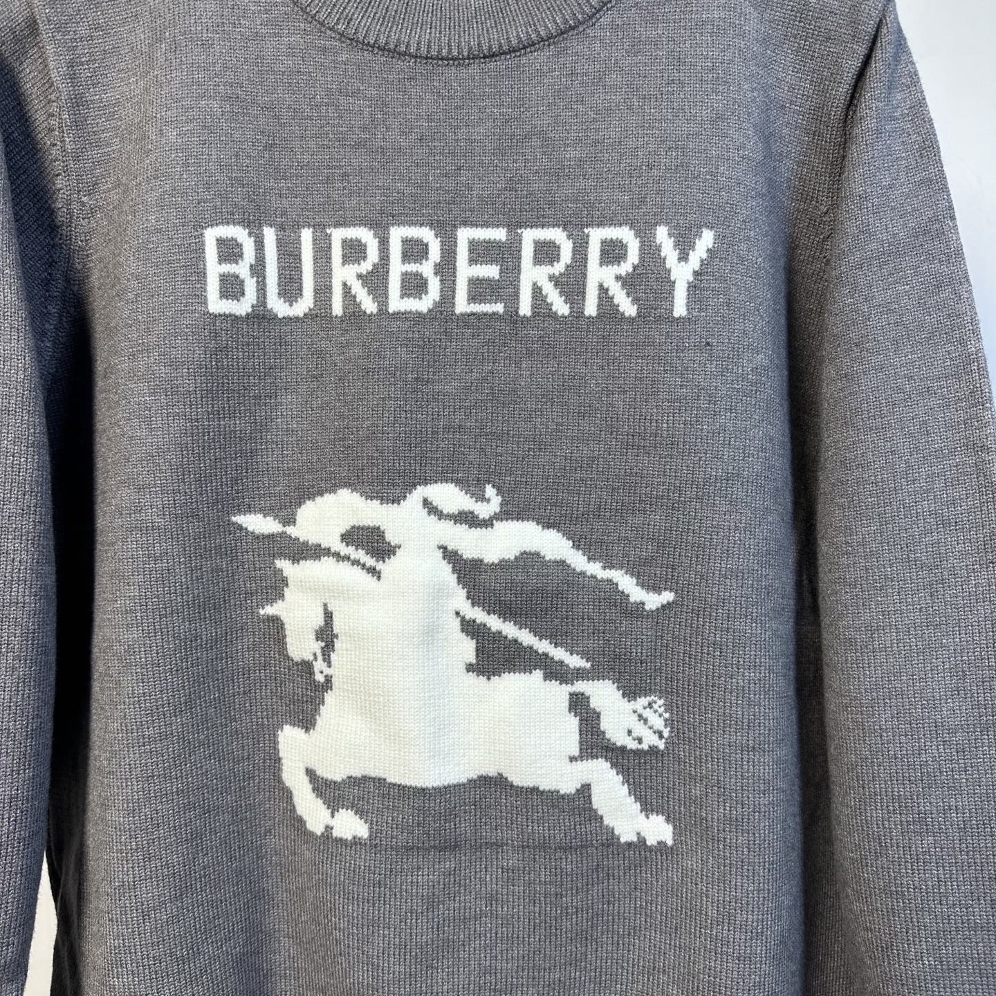 Gray Burberry sweater with 'BURBERRY' text and white horse graphic
