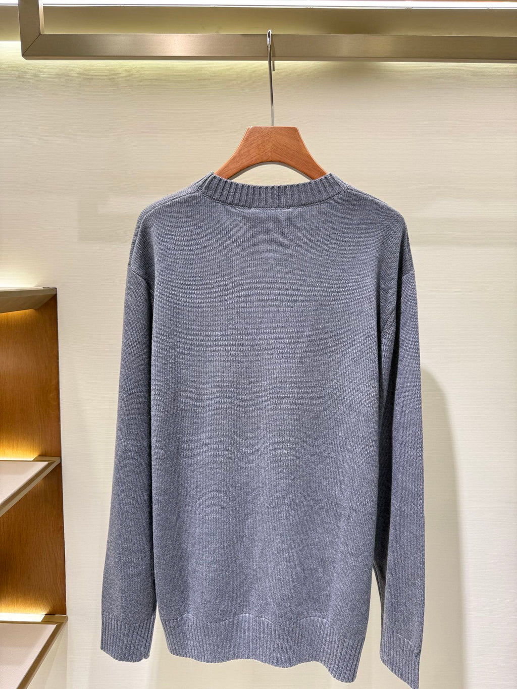 Gray crewneck knit sweater with long sleeves, plain back view.