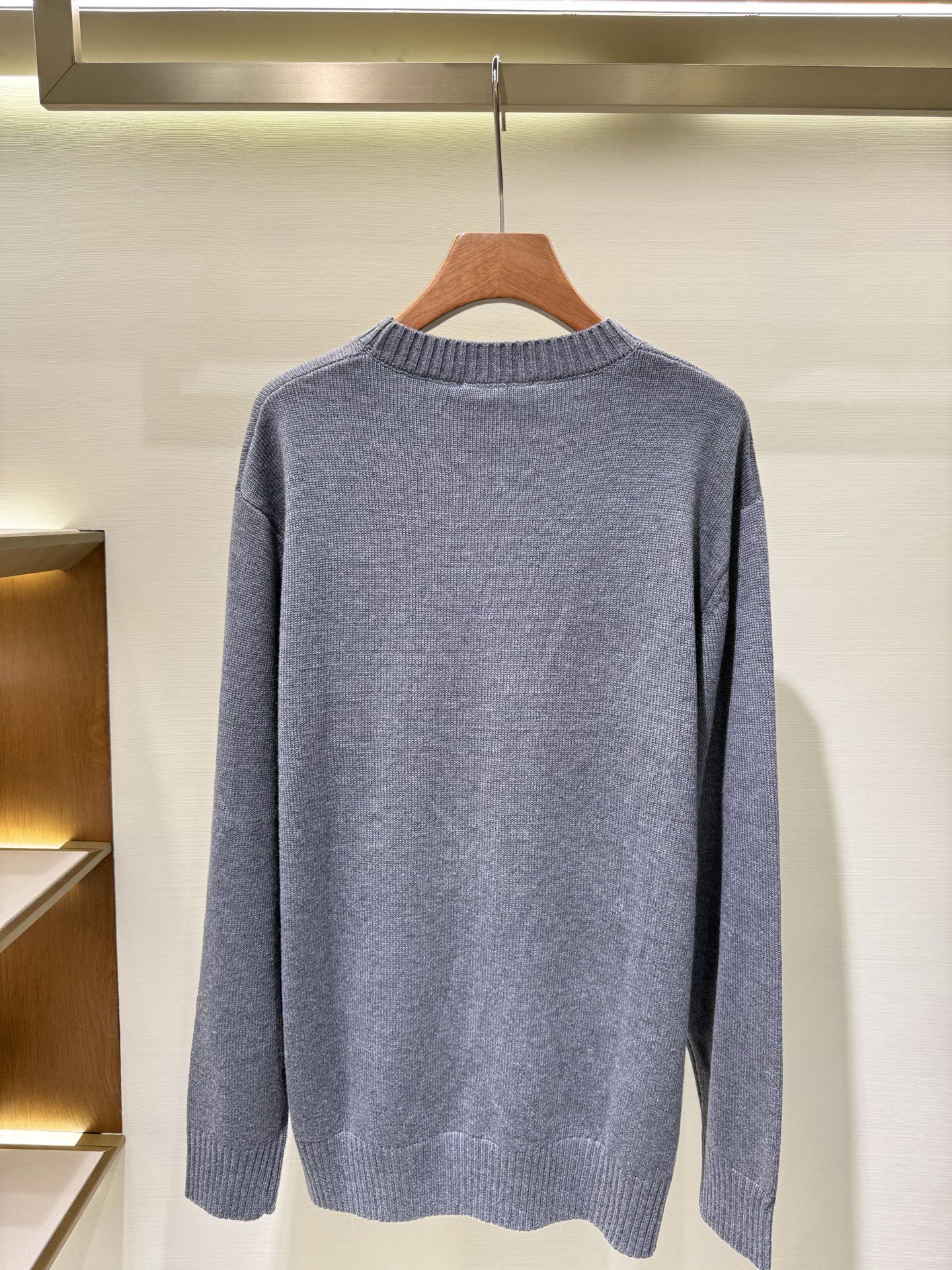 Gray crewneck knit sweater with long sleeves, plain back view.