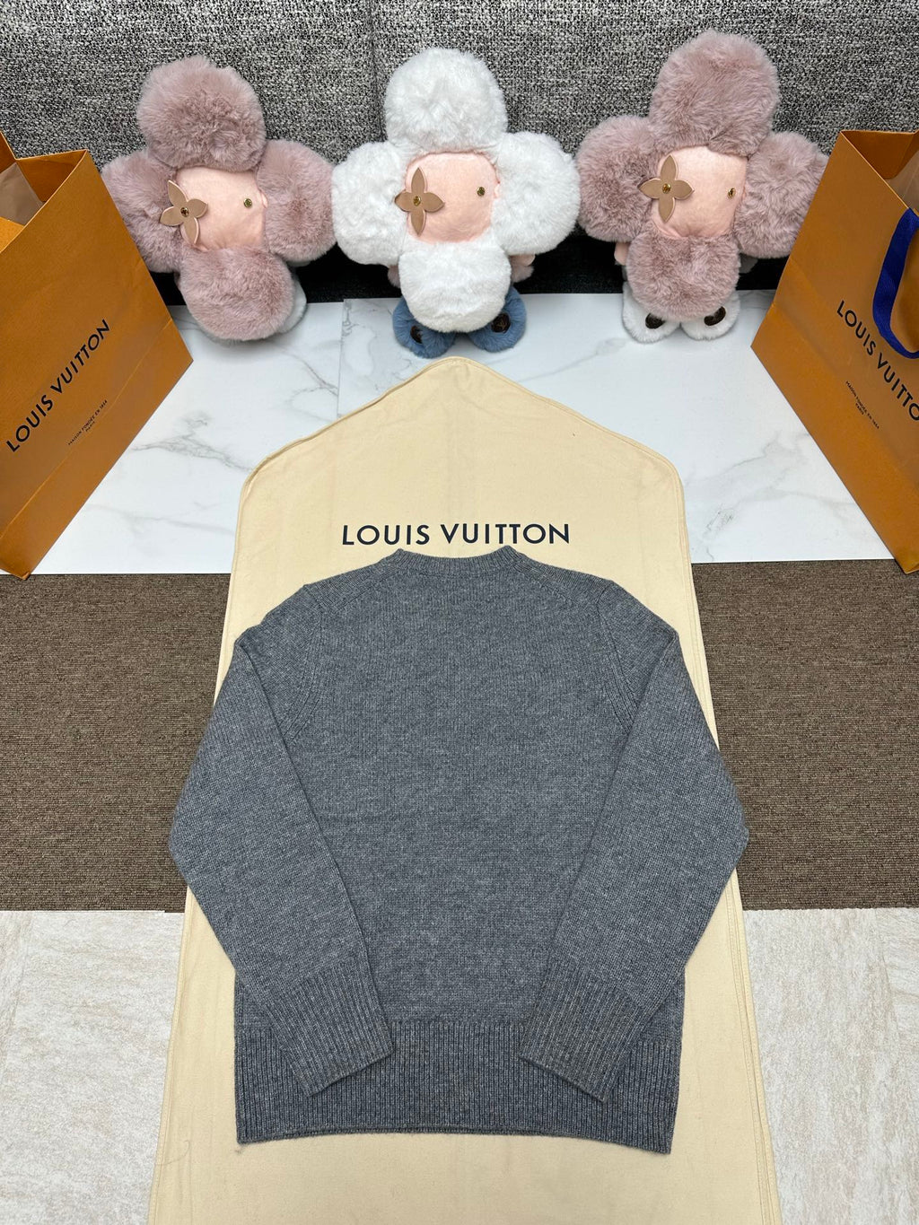 Grey knit sweater back view with ribbed hem and crew neck