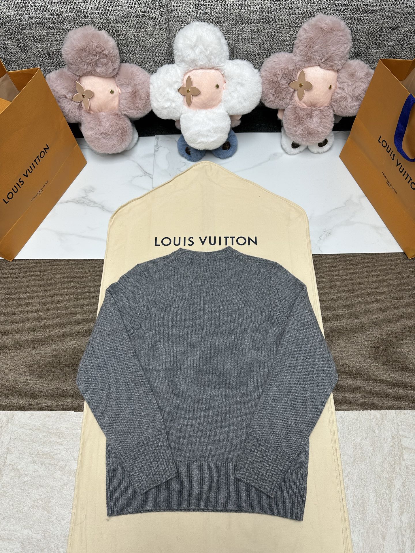 Grey knit sweater back view with ribbed hem and crew neck