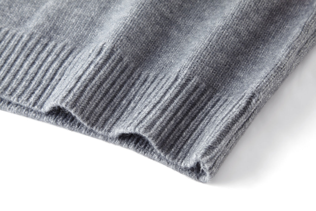 Close-up of gray sweater hem with ribbed knit edge and texture.