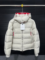 Long white puffer jacket with red inner hood, zip front, and quilted shoulders
