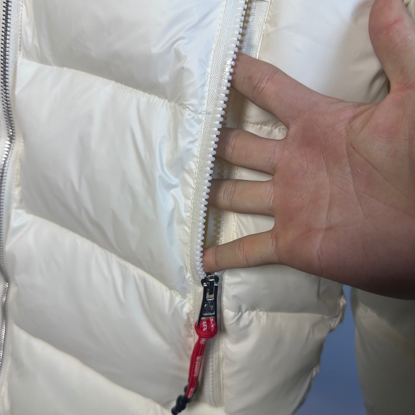 Moncler long puffer jacket side zipper with red pull tab