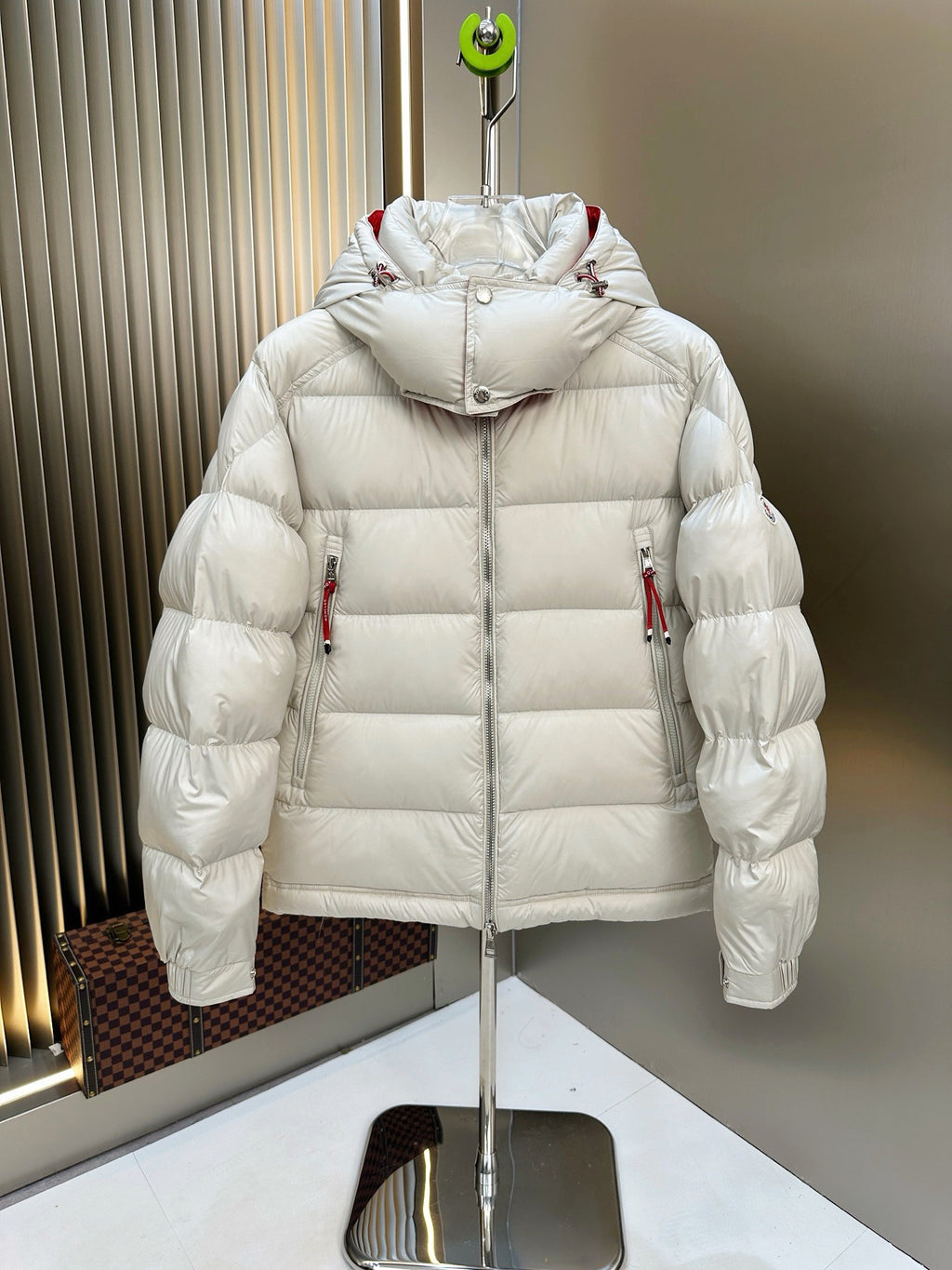 Long puffer jacket with attached hood, white quilted fill, red trim at shoulders