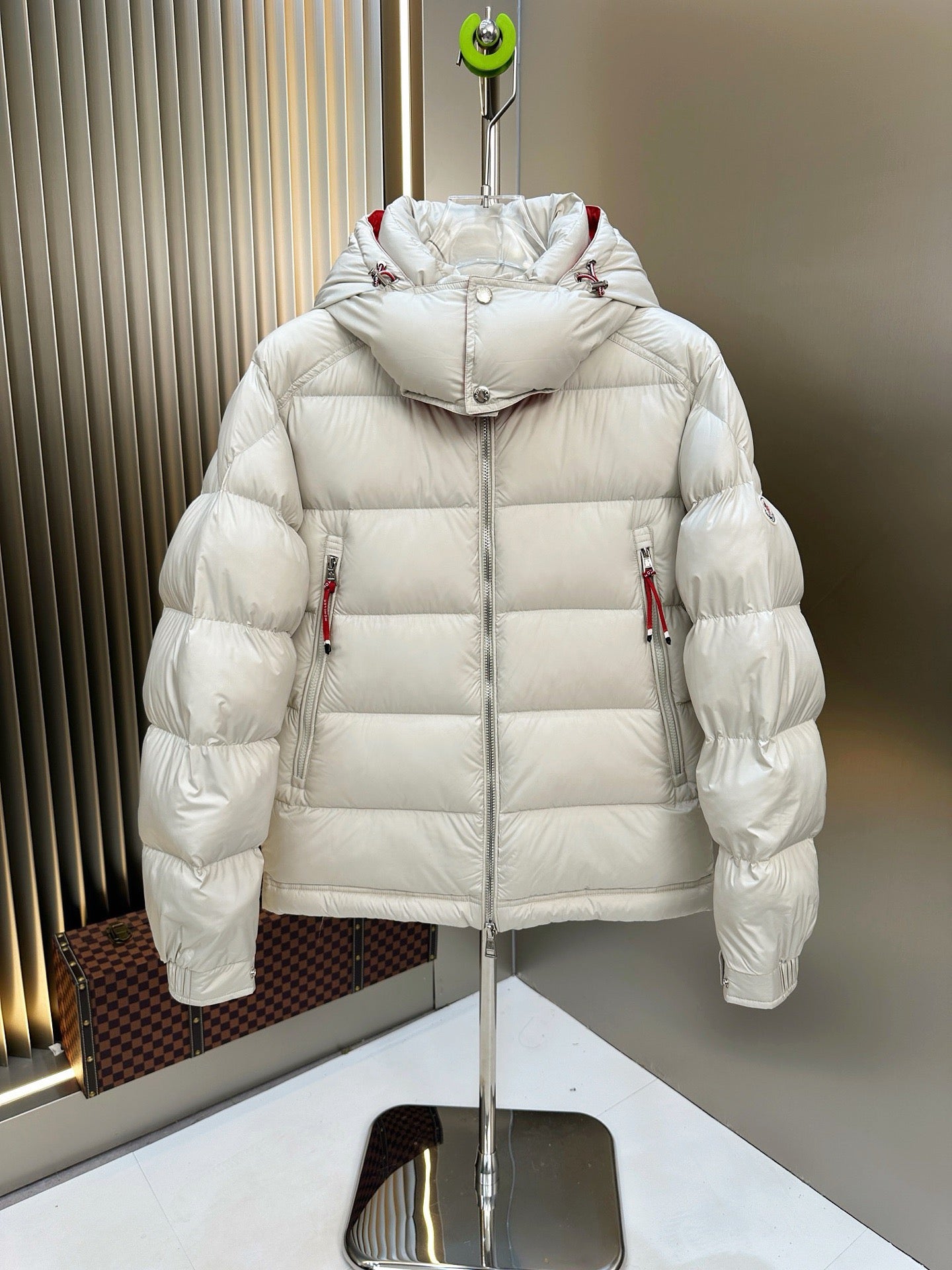 Long puffer jacket with attached hood, white quilted fill, red trim at shoulders