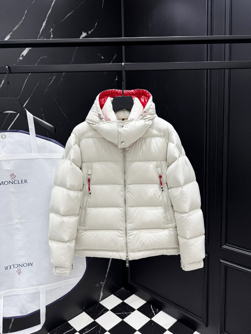 White long puffer jacket with red hood lining, zip front, and side zip pockets