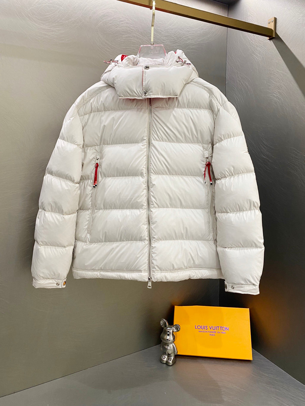 White long puffer jacket with hood, front zip, and two side pockets