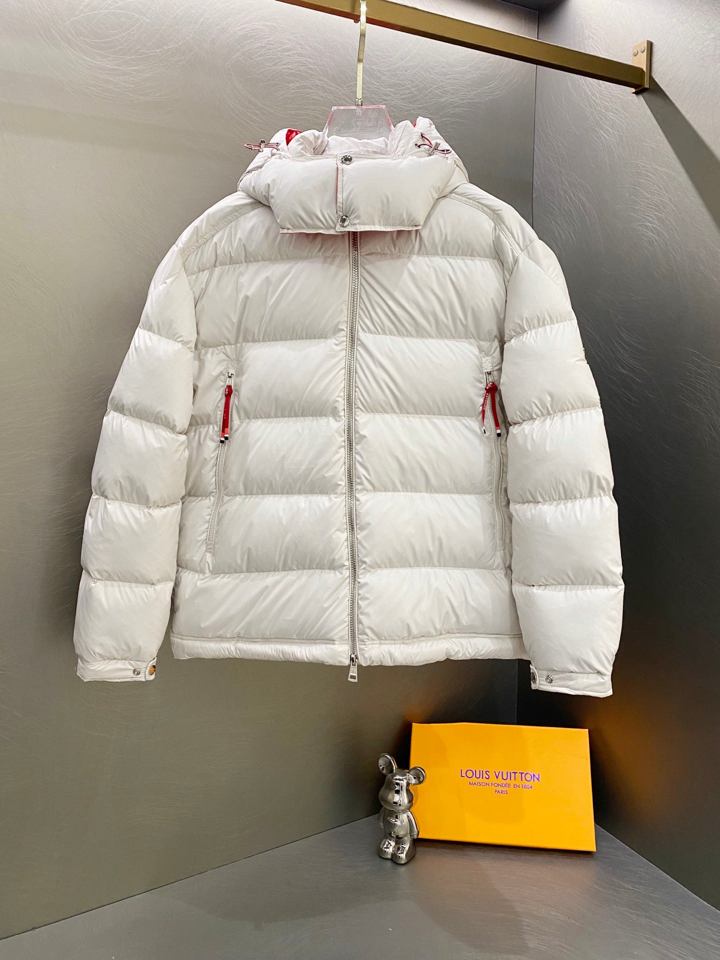 White long puffer jacket with hood, front zip, and two side pockets
