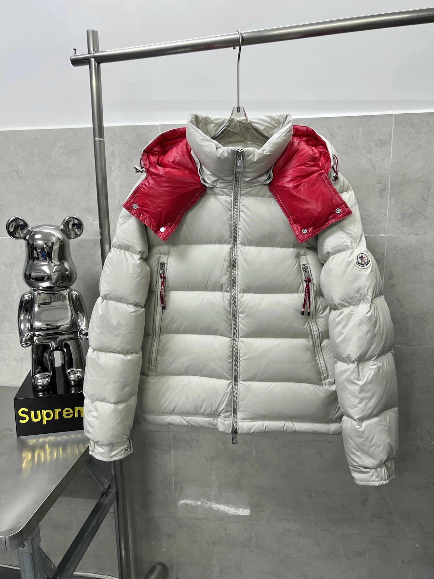 Long puffer jacket front view, white quilted insulation with red shoulder accents