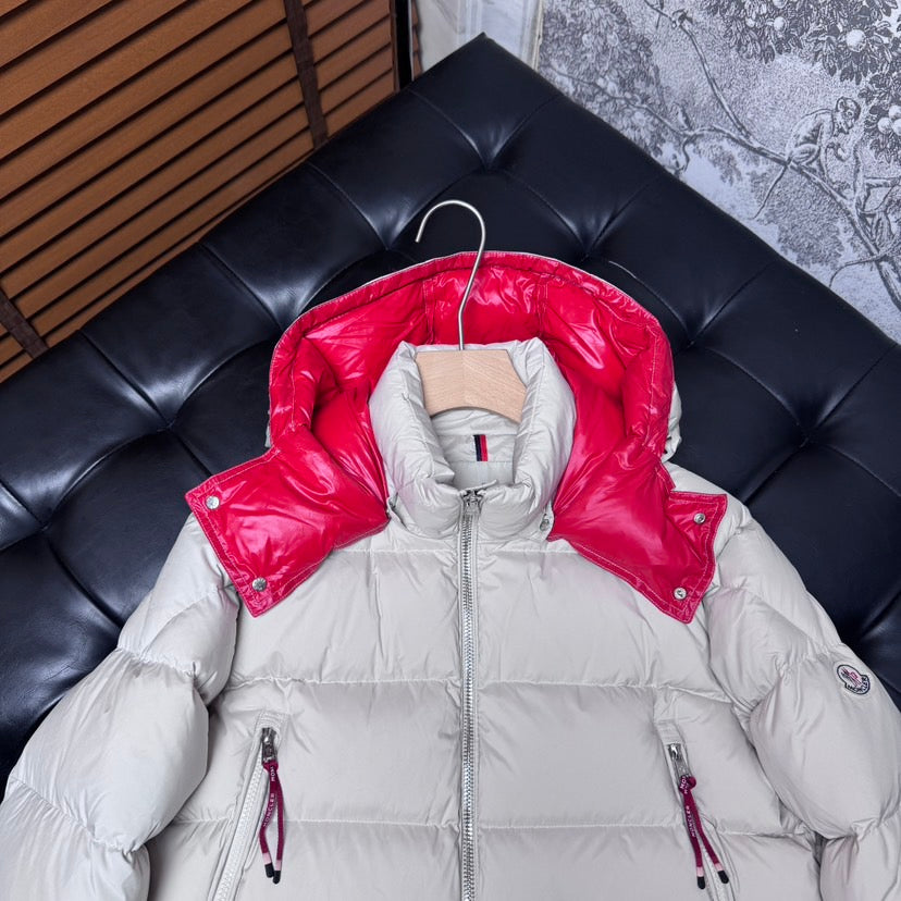 Moncler long puffer jacket with red hood lining, front zipper and logo sleeve patch