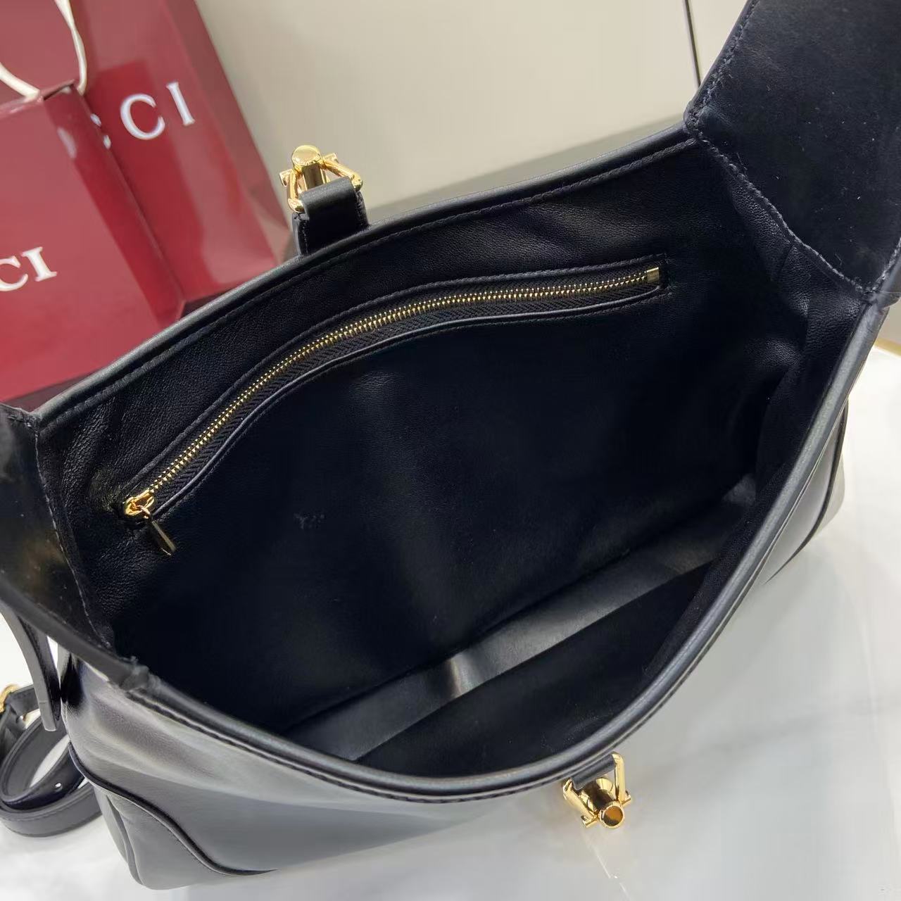 Black hobo bag interior with top zip pocket and gold-tone zipper pull