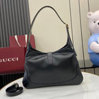 Black leather hobo bag with curved handle and gold-tone front clasp