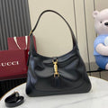 Black leather hobo bag with curved top handle and gold-tone front clasp hardware